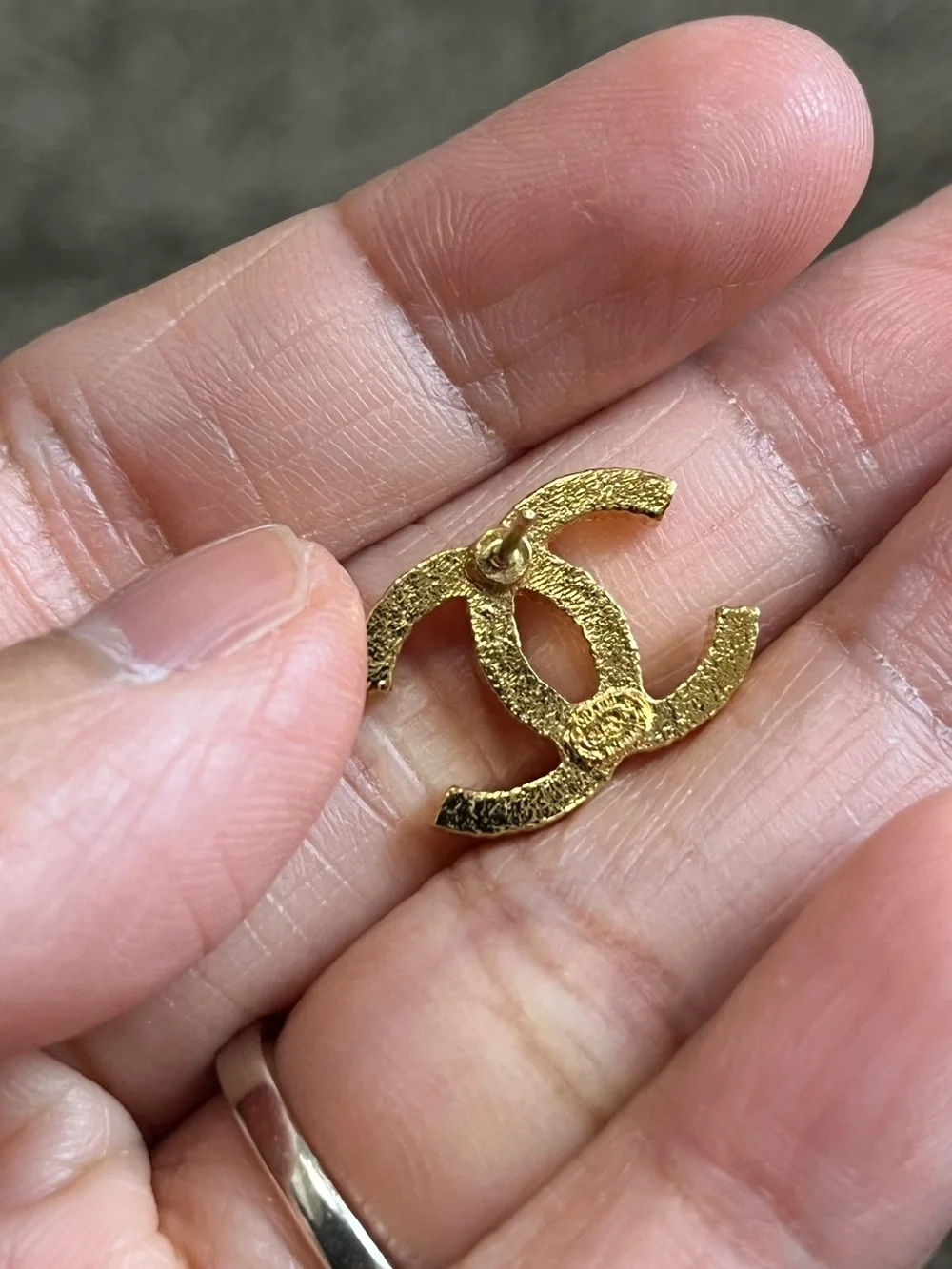 CHANEL Gold Interlocking CC Stud Earrings on Black